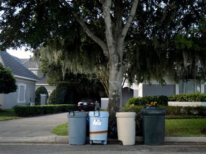 The tree damaged by Tiger Woods in his auto accident is surrounded by plastic garbage cans in the Isleworth community in Windermere, Fla., Monday, Nov. 30, 2009.