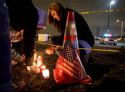Janai Roberts, 17, lights a candle in front of a growing display of flowers, candles, and messages of sympathy in front of the Forza Coffee Company in Parkland, Wash., Monday, Nov. 30, 2009, where four Lakewood Police Officers were fatally shot Sunday morning as they sat in the coffee shop.