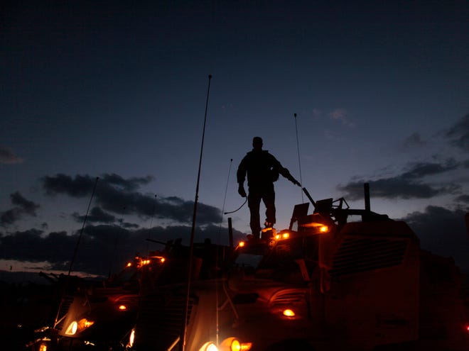 A soldier from Golf Battery 4th 317 stands atop a vehicle as they prepare to go out on night patrol at Forward Operating Base Airborne, near the town of Maidan Shar, Wardak province, Afghanistan Tuesday Dec. 1, 2009. In the next hours, President Obama will outline his Afghan war strategy speech at the West Point military academy.