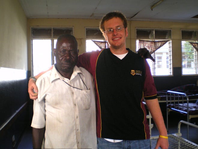 Troy Curtis (right) stands next to Surgical Assistant Tom Koto at a hospital in Iganga, Uganda. Curtis is raising money to build a $10,000 ward for tuberculosis patients in the hospital.