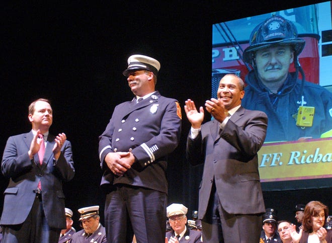 Lt. Tim Murray and Gov. Deval Patrick applaud Randolph firefighter Richard Potter after he accepted a Meritorious Group Award on behalf of his department on Thursday, Dec. 3, in Worcester.