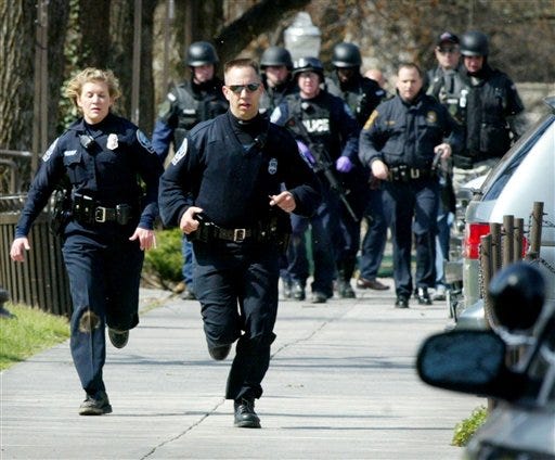 In a Monday, April 16, 2007 file photo, Blacksburg police officers run from Norris Hall on the Virginia Tech campus in Blacksburg, Va. (AP Photo/The Roanoke Times, Matt Gentry, File)