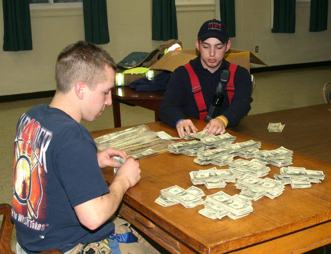 Jesse, left, and and Kyle Long of the Dayville Fire Department count money raised from the department's annual Boot Drive for the Tommy Toy Fund on Saturday, December 5, 2009.