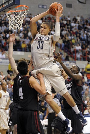 UConn's Gavin Edwards grabs a rebound over Harvard's Jeremy Lin, left, and Kyle Casey, right, on Sunday during the second half of UConn's 79-73 victory in Storrs.