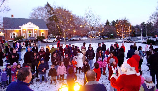 Standing on Norwell’s town common, Santa is surrounded by people who turned out for the holiday tree lighting.