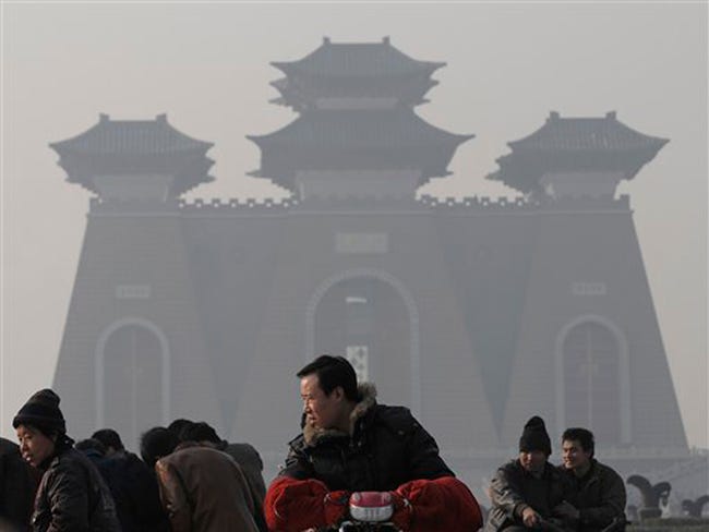 Chinese visit a tourist spot shrouded in fog, caused by air pollution, in Linfen, Shanxi province, China, Sunday, Dec. 6, 2009. Delegates converged Sunday for the grand finale of two years of tough, sometimes bitter negotiations on a climate change treaty, as U.N. officials calculated that pledges offered in the last few weeks to reduce greenhouse gases put the world within reach of keeping global warming under control.
