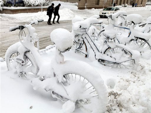 Snow covered bikes sit in a bike rack in front of Science Hall on the University of Wisconsin-Madison campus in Madison, Wis, Wednesday, Dec. 9, 2009. Madison received 15-18 inches of snow that canceled classes Wednesday.