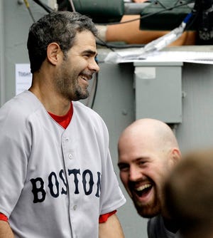 Mike Lowell, left, shares a laugh with Kevin Youkilis in the dugout after Lowell's two-run home run off White Sox starting pitcher John Danks during the fourth inning of the Red Sox' 6-1 victory on Sunday in Chicago.