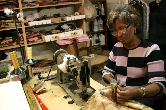 Dorothy McNish, the co-owner of M & M Upholstery, sews a couch cover together for a piece of furniture that will be re- upholstered at the shop.