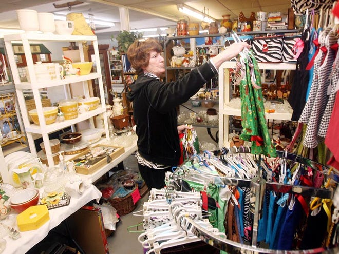 Rebecca Miller hangs new children’s clothing inside her booth at Almost Antiques and Thrift Store on Wednesday. Miller said she has sold items at various locations for several years. She sells new and used products.