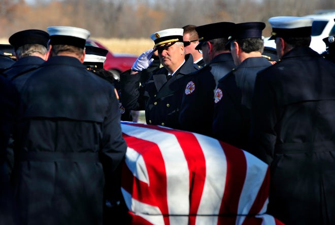 Peoria Fire Department Battalion Chief Doug Brignall is honored during graveside ceremonies at Kingston Mines Cemetery. Brignall's casket was carried on the back of a fire engine as the funeral procession traveled from Peoria to Kingston Mines Friday.