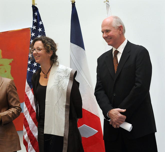 Bill Sharp, president of Cytoo, and Alexandra Fuchs, co-CEO and co-founder, stand next to French and American flags during a ceremony for the French-based biotechnology company at the Meadows building on Rte. 9 in Framingham on Friday.