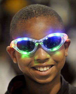WILL DICKEY/The Times-UnionColumbus Ashley, 10, shows off his light-up sunglasses Saturday. Gifts also included MP3 players, balls and dolls.