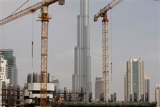 The Burj Dubai, the worlds tallest building under construction, is seen in the background as construction workers are seen at a site at the Business Bay district in Dubai, United Arab Emirates, Monday, Nov. 30, 2009. On the first day of trading since news of Dubai World's debt crunch became public, Dubai's main stock exchange dropped more than 7 percent while the Abu Dhabi exchange fell more than 8 percent, the steepest fall in at least a year, according to brokers.