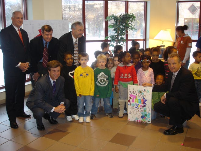 Top row, left to right, William Payne, former Old Colony YMCA board chairman; Alan Perrault of Jay Cashman Inc.; and Vincent Marturano, president and CEO of the Old Colony YMCA. Bottom row, Randy Papadellis, Old Colony YMCA board chairman, and Jay Cashman flank a group of children at the Y