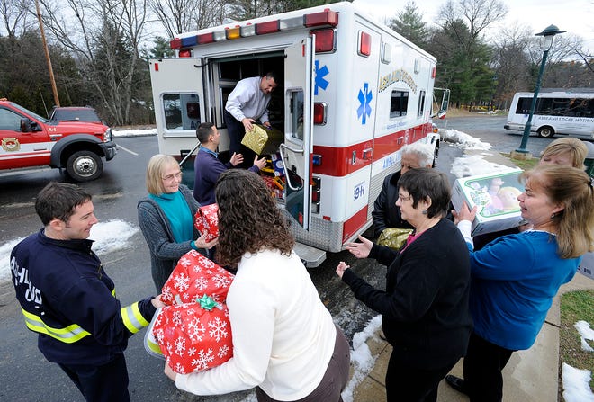 From left, Ashland Firefighter Shawn Payton, Ashland Senior Center Director Joanne Duffy, Firefighter Mark Catarelli, Recreation Director Kelly Rund, Lt. David Iarussi, administrative assistant Jan Borelli, outreach coordinator Susan Wells, Gabe Murgerian and Judy Belcher help load an ambulance with gifts collected by the Ashland Fire Department Association. They will be driven to the Youth and Family Services offices for their annual Holiday Gift Drive.