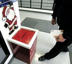 Photo by Amy Paterson/New Jersey Herald Newton Postmaster Jack Bileci carries a letter to Santa after collecting it from Santa’s Mailbox in the post office lobby.
