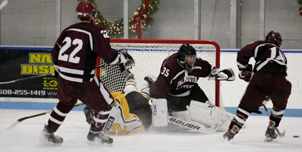 Nauset’s Troy Niezgoda winds up in the Falmouth net behind goalie Brandon Moore as the Clippers’ Connor Megan follows the play and Kyle Boudrot skates away with the puck Wednesday night.