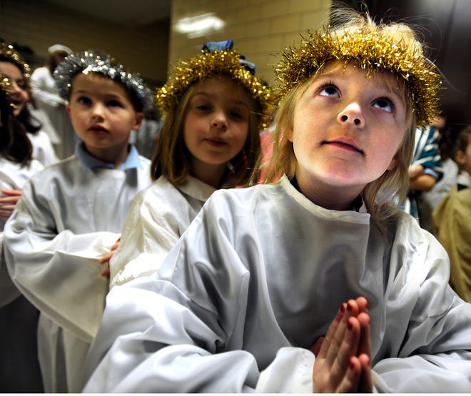 Samantha Centola, who plays an angel in St. Bridget School's Christmas program, waits with her fellow angels for their cue during a dress rehearsal yesterday in Framingham.