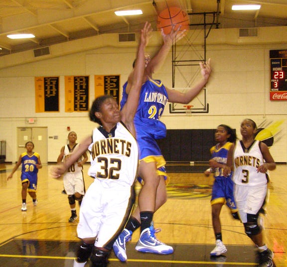 East Ascension’s Alexis Ruth gets off a shot attempt in transition ahead of Scotlandville’s Haylea Rheams in the third quarter of the Lady?Spartans’ 45-40 victory Tuesday night at Scotlandville Magnet High School.
