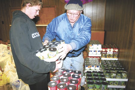 Dale Deter, a Burr Oak high school student, and Ted Eckert, food pantry supervisor, helped unload the 3,000 pounds of food donated by local 4-H clubs to the Burr Oak food pantry.