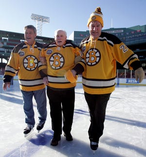 Boston Bruins legends Ray Bourque, left, and Terry O'Reilly, right, help Milt Schmidt from the ice during the First Skate at Fenway, Friday, Dec. 18, 2009, in Boston.