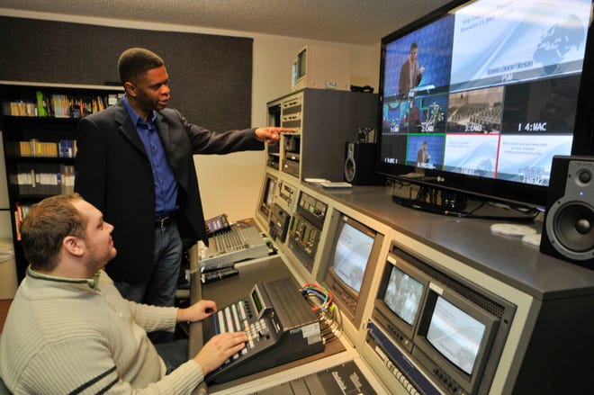 Pastor Ricky Temple talks with, right, talks with Joshua Cunning in the control room at Overcoming By Faith. (Steve Bisson/Savannah Morning News)