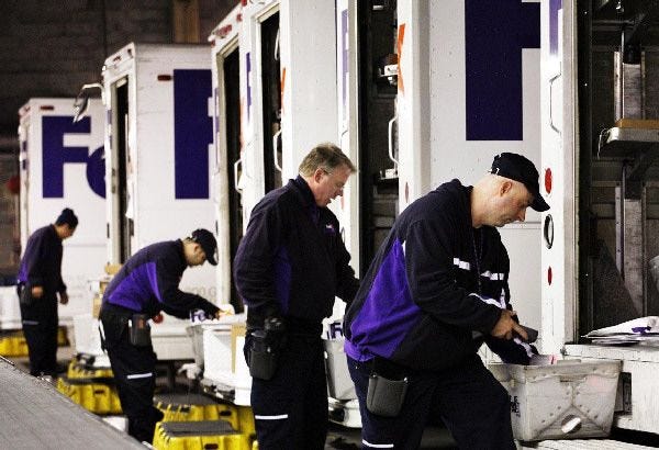 Drivers organize packages for their delivery trucks at a FedEx facility in the Queens borough of New York.