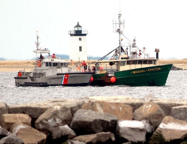 A Coast Guard cutter tows the disabled lobster boat Michael & Kristen past Long Point Lighthouse in Provincetown yesterday morning. The lobster boat had been disabled since Wednesday after experiencing engine failure southeast of Nantucket.