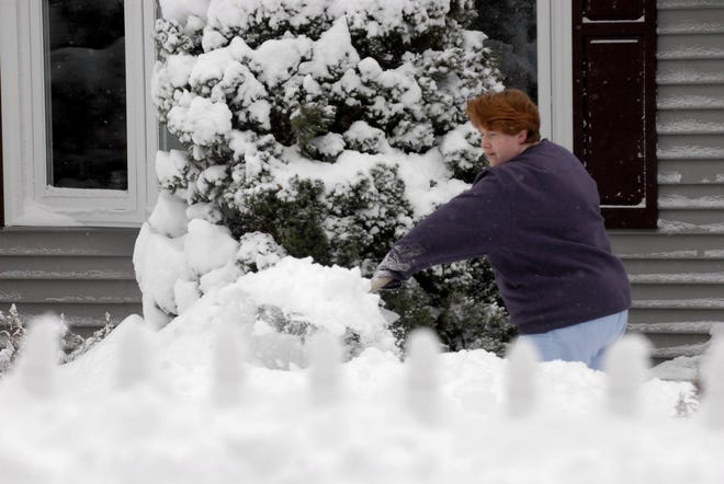 Jackie Carrell of Norwich, shovel her walkway in front of her house on Dudley Street, Sunday, Dec. 20, 2009 after a snow storm in Norwich.