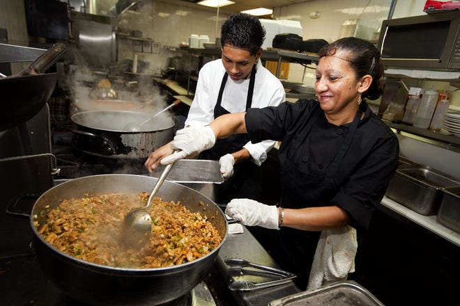 Edgar Olmedo, left, and Maria Sagastume work on dishes during food preparation at the Ocala restaurant Latinos y Mas on Friday. The same food preparation precautions practiced religiously by commercial chefs should be taken when preparing holiday meals at home.