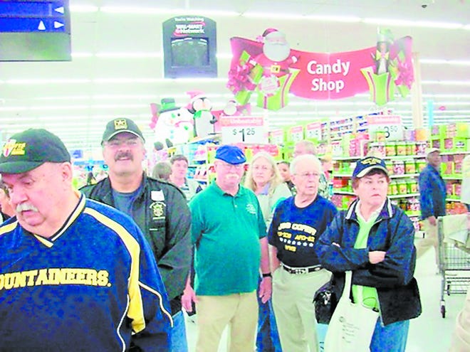 Volunteers await the arrival of children for the special Christmas shopping spree. By MICHAEL ISAM, Special to The Record