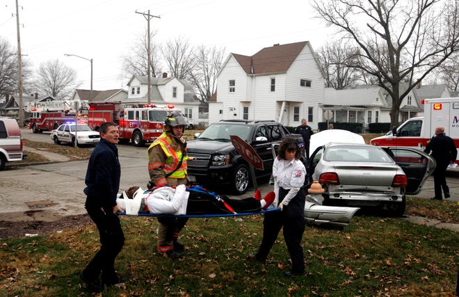 Emergency personnel transport a victim from a car crash at Eighth and Laurel streets to a waiting ambulance on Tuesday, Dec. 22, 2009. According to police the Avalanche was traveling southbound on Eighth Street, stopped at the stop sign, then proceeded into the intersection before broadsiding the Stratus which contained several children. The extent of the children's injuries was not serious, police said, but they were taken to the hospital as a precaution.