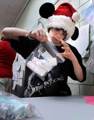 Jared Donovan and other students in the Mindess School's Neighborhood Program on Thursday assemble packages of socks and underwear for the charity Cradles to Crayons, a Quincy-based nonprofit that aids children of low-income families.