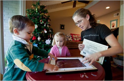 Rebecca Young of Mountain View, Calif., and her 3-year-old twins, Jason and Lea, framing the carbon reduction certificate they received for Christmas.