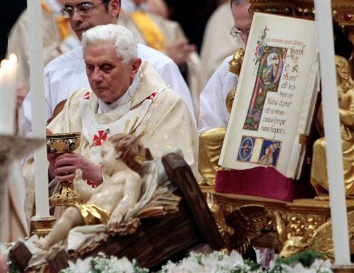 Pope Benedict XVI is seen next to the statuette of baby Jesus, in foreground, during Christmas Mass in St. Peter's Basilica at the Vatican, Thursday, Dec. 24, 2009. A woman jumped the barriers in St. Peter's Basilica and knocked down the pontiff as he walked down the main aisle to begin Christmas Eve Mass on Thursday, a Vatican spokesman said. The Rev. Ciro Benedettini said the 82-year-old pope quickly got up and was unhurt.
