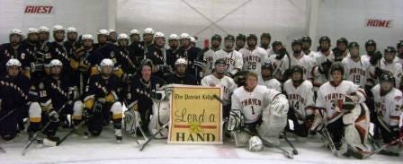 The Xaverian Brothers High School hockey team, left and the Thayer Academy team stand with the Lend a Hand banner after their annual scrimmage that raised $670 for Lend a Hand.