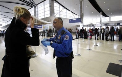 Paul Marshall, a Transportation Security Administration agent, helping an international traveler at the Detroit airport on Saturday. Heightened screening was in effect at airports worldwide.