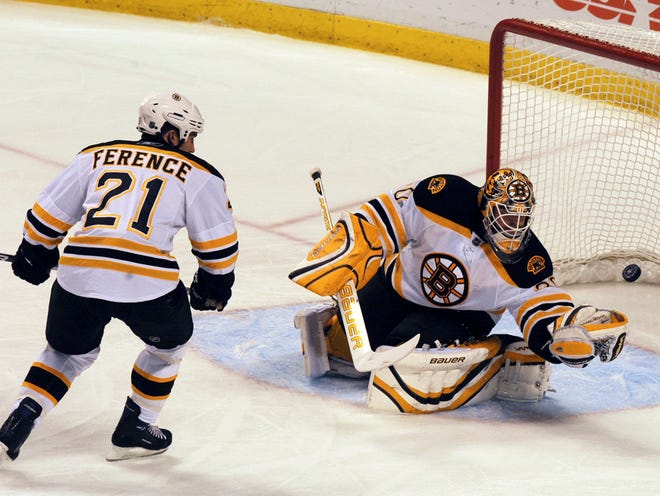 Boston's Andrew Ference (21) watches as goalie Tim Thomas makes a save in the second period of the Bruins' 2-1 win at Florida last night.