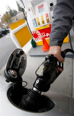 In this Dec. 2, 2009 file photo, Shell gas station attendant Toke Fusi pumps gas for a customer in Menlo Park, Calif.