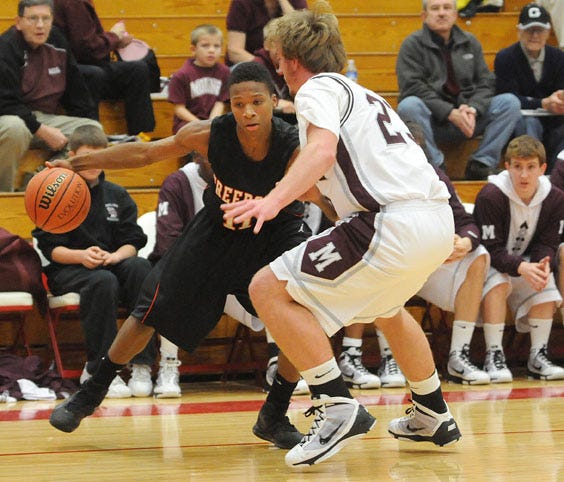 Freeport's Jalen Carroll crosses over his dribble against Moline's Mikel Wismer Monday during the Pekin Insurance Holiday Tournament.