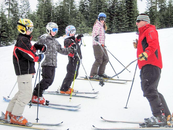 Getting tips from Mt. Shasta Ski Team program director Robert Baker during the Christmas camp at the Ski Park are Far West racers Jarrod Althaus-Cressman, Harrison Keane, Elise Balin and Mariah Althaus-Cressman.