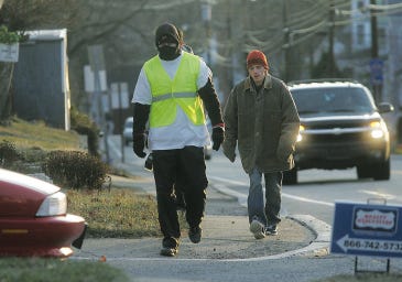 Photos by Daniel Freel/New Jersey Herald Luke Barbalich, left, of Montague, is accompanied by friend Josh Szelesta, of Newton, as Barbalich walks south on High Street, in Newton, Wednesday morning. Barbalich walked 24.2 miles to work from his Montague home to raise awareness of homelessness.