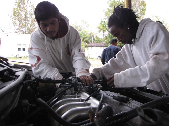 Luis Lopez, left, a ninth-grader at Horizon Center, and Charles Bell, a 12t-grader at Buchholz High School, repair a Ford Escort as interns in the automotive repair program offered at The Dignity Project.
