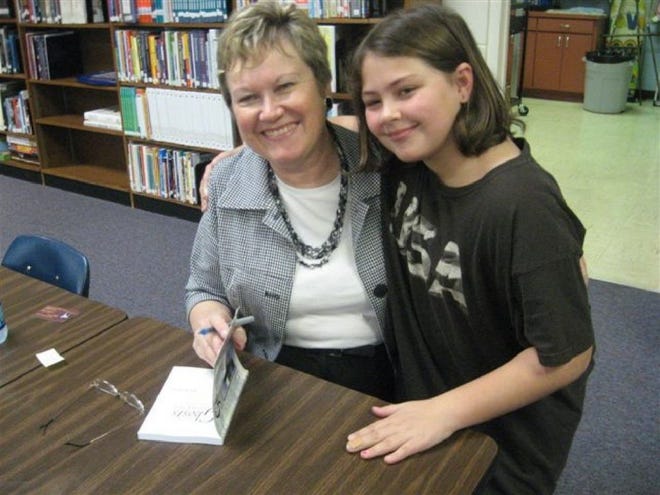 Provided by Janie LloydAuthor Jane Wood poses for a picture as she autographs one of her books for a Clay Hill Elementary fourth-grader.