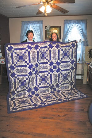 Tonya Reichard of Waynesboro, left, is shown with the mystery quilt she made for her daughter Melinda, right. Reichard’s quilt is entered in the 2010 Pennsylvania Farm Show.