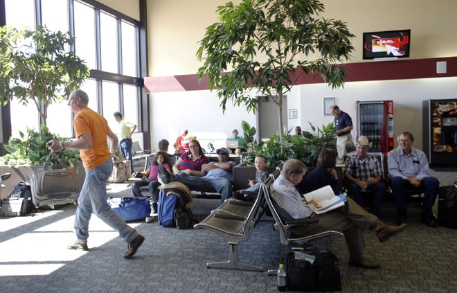 Passengers wait in the airport terminal to board flights to Chicago and Myrtle Beach.