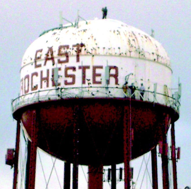 Workers from R.M. Lill on top of the East Rochester water tower and on the catwalk, which circles the middle of the tower, begin rehabilitation work.