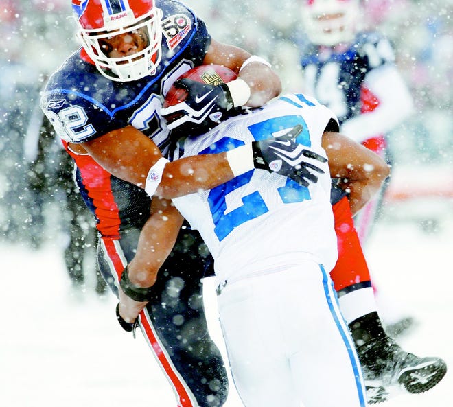 Buffalo running back Fred Jackson (22) is stopped by Indianapolis defender Jacob Lacey during the first half of Sunday's snowy game in Orchard Park.