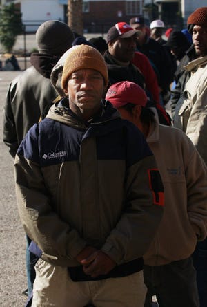 KELLY JORDAN/The Times-UnionMelvin Collins, who has been homeless for about a year and a half, waits in line outside the City Rescue Mission in Jacksonville.
